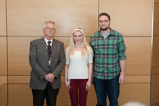 Emma Watson and Colin Conine, pictured with Dean Anthony Carruthers, receive recognition for winning Harold W. Weintraub Graduate Student Awards.