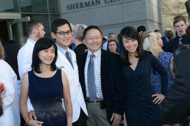 Kevin Gao dons his new white coat with father Guangping Gao, PhD, and family.