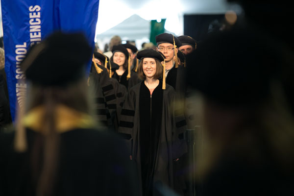 Margaret Heider, PhD, enters the tent with her GSBS graduates.