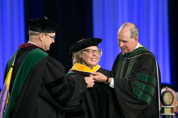 Claire Pomeroy, MD, MBA, receives an honorary degree from Dean R. Terence Flotte (left) and Chancellor Michael F. Collins.