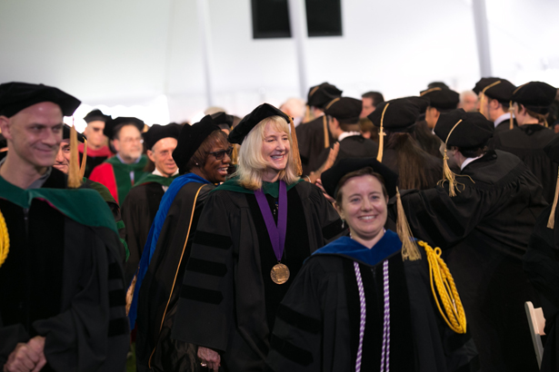 Luanne Thorndyke, MD, enters the tent behind faculty marshal Jessica Pagano-Therrien, PhD.