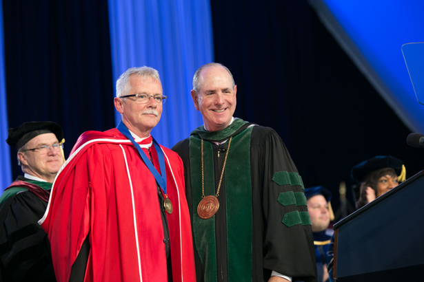 GSBS Dean Anthony Carruthers accepts the Chancellor’s Medal from Chancellor Michael Collins.