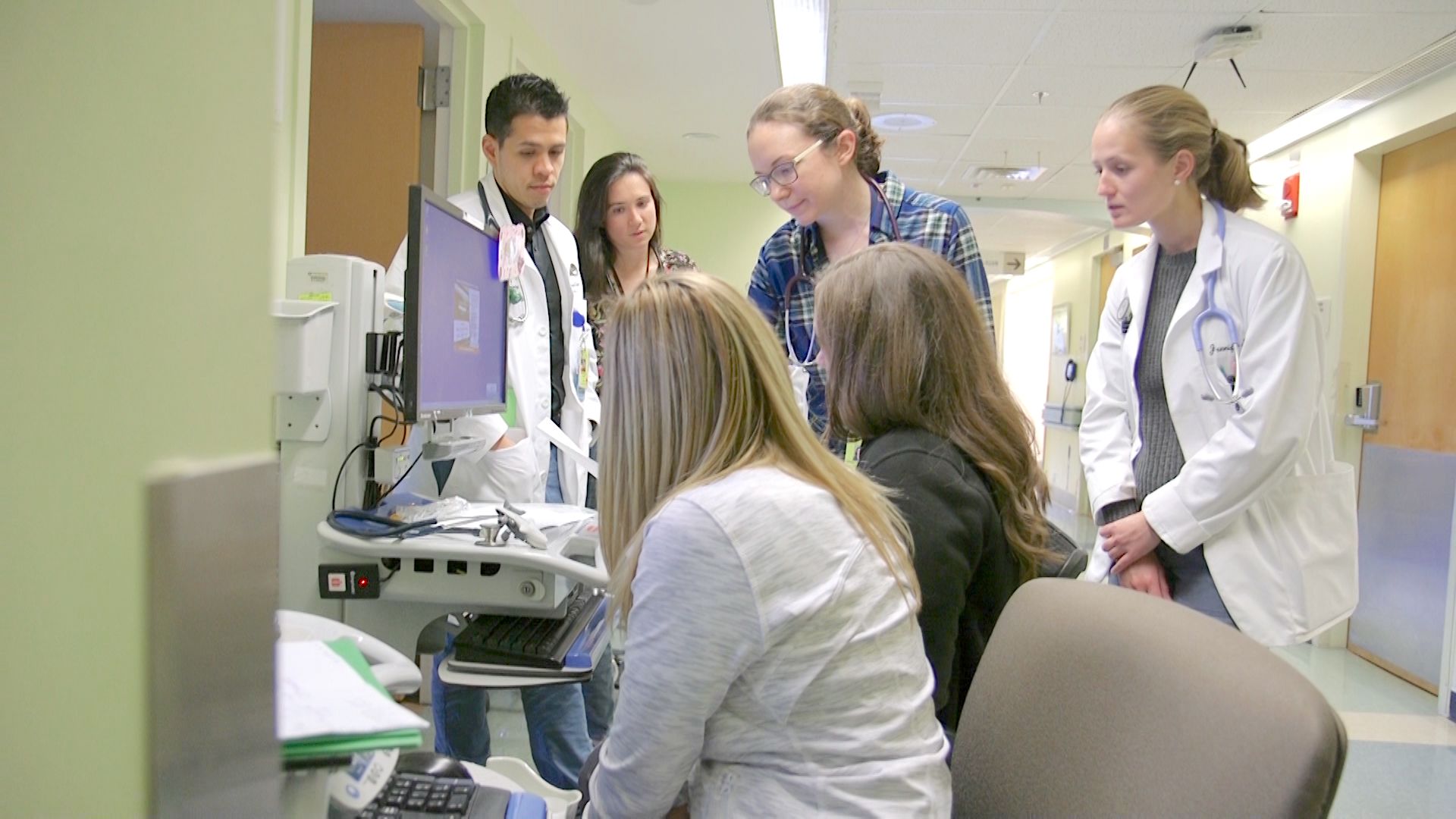 Group of medial personal in hall of hospital discussing a process