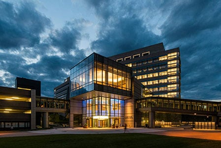 Albert Sherman Center lit up at night against a deep blue night sky