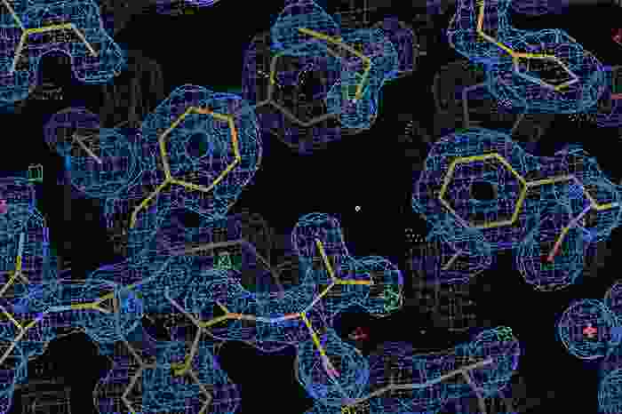 sticks forming hexagons and other molecule looking structures surrounded by a blue mesh in a black background