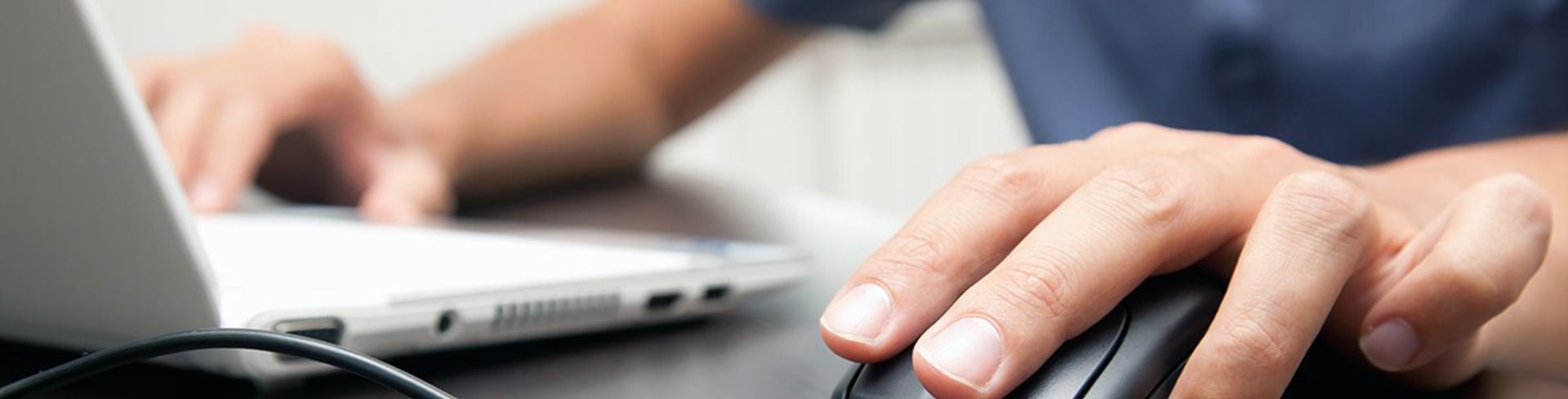 Closeup of hands working at a laptop