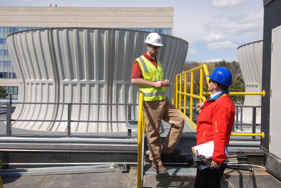 two people near campus cooling tower