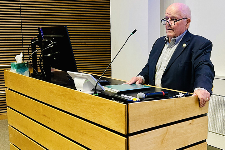 William Ostiguy delivering remarks at a podium.