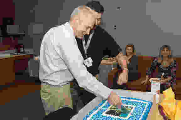 Dr. Makris cuts the cake