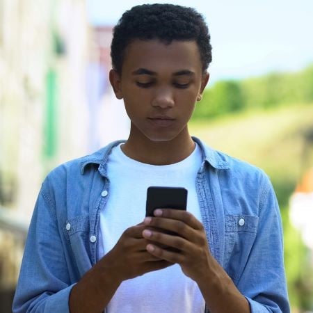 black young male outside on cellphone