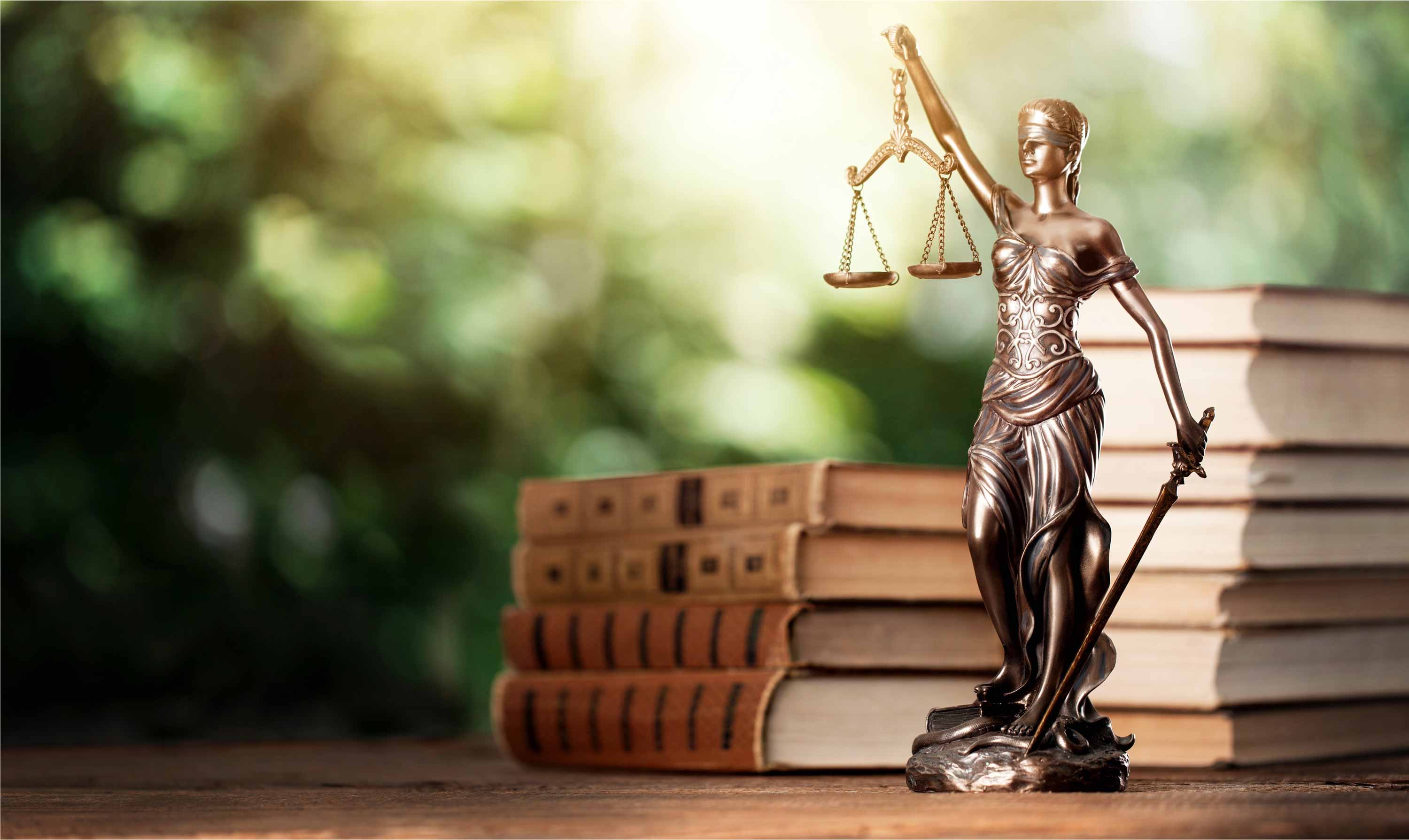 justice figurine on desk with books