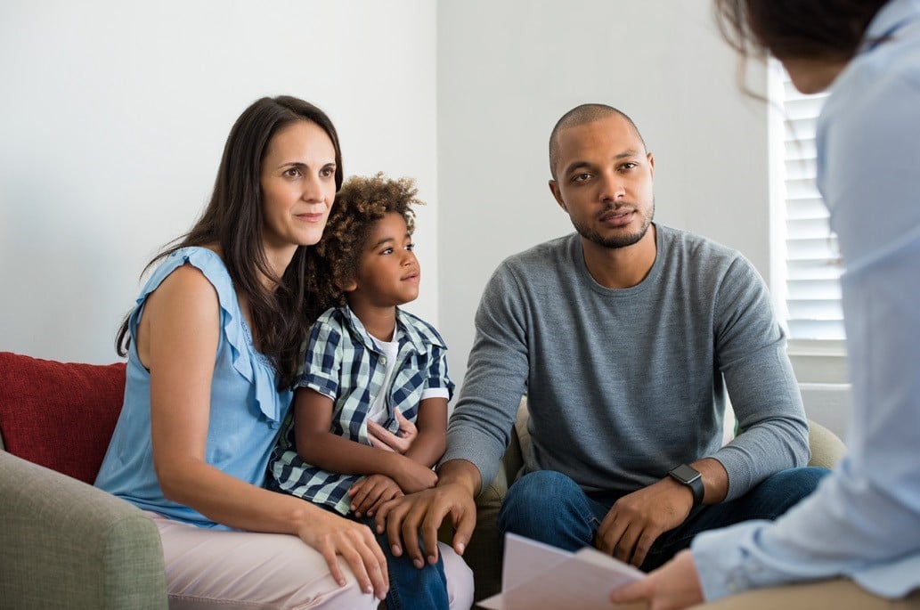 multi ethic family mom dad daughter in a therapy session