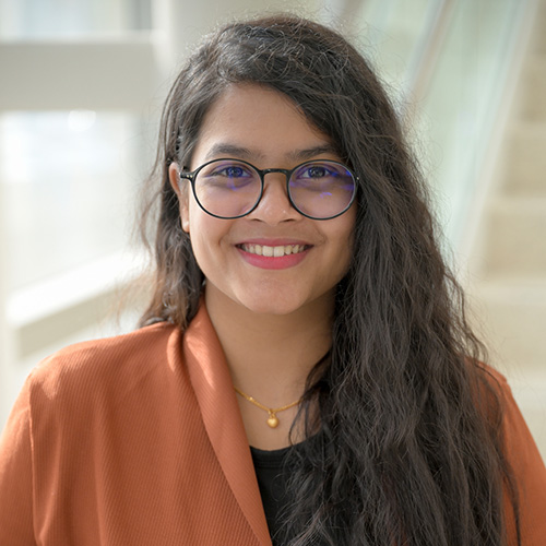 indian woman with long dark wavy hair and glasses