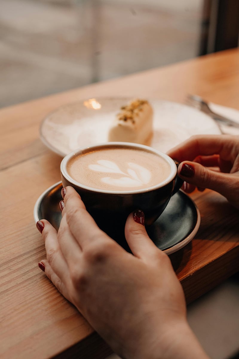 unseen person holding cup of coffee