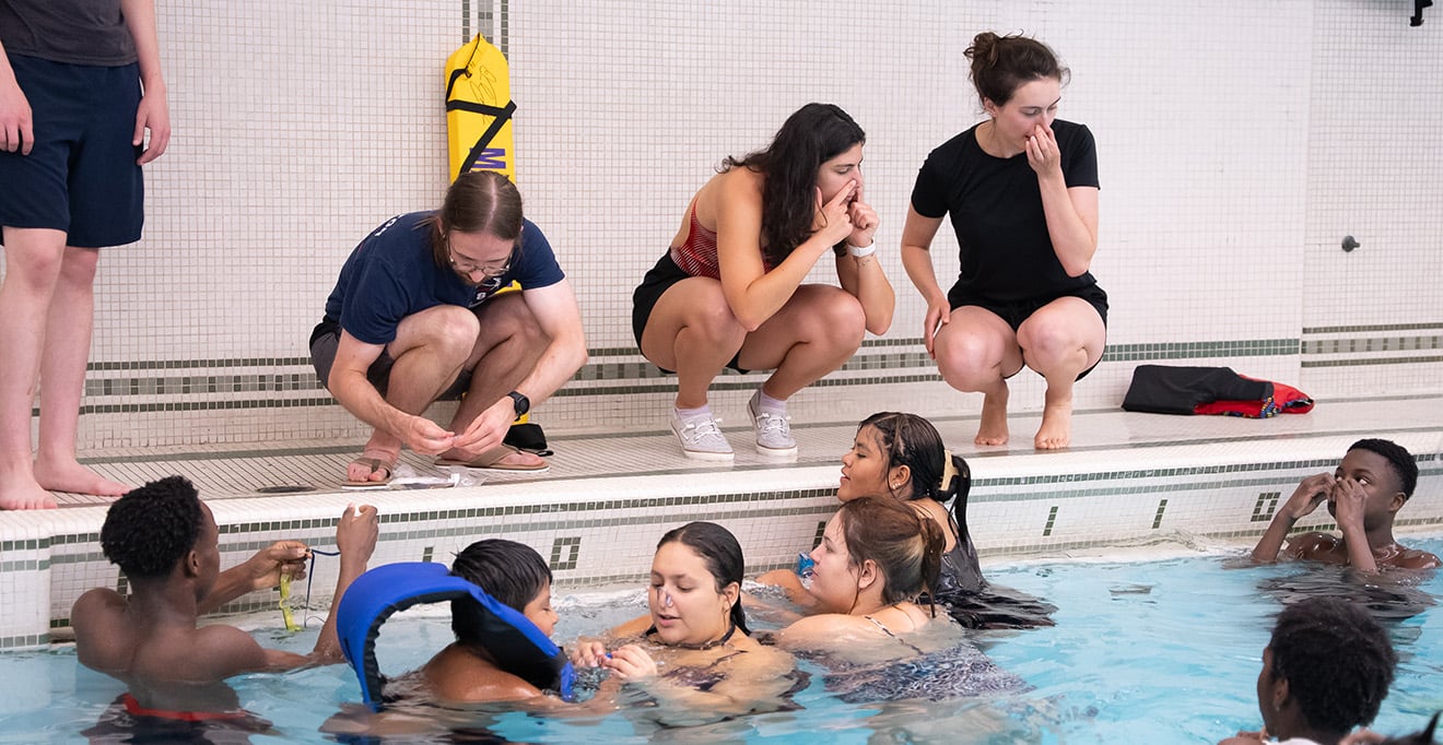 Medical student Michael Bedard, Victoria Taieb and Alicia Bergeron instruct swimmers on how to place nose clips
