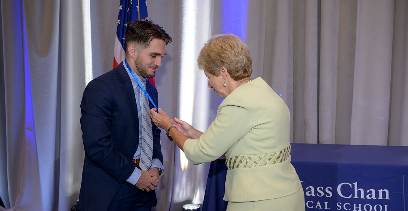 Class speaker Timothy Heaney, here with Joan Vitello-Cicciu, PhD, received a pin to signify his completion of the pre-licensure year of the Graduate Entry Pathway Program.