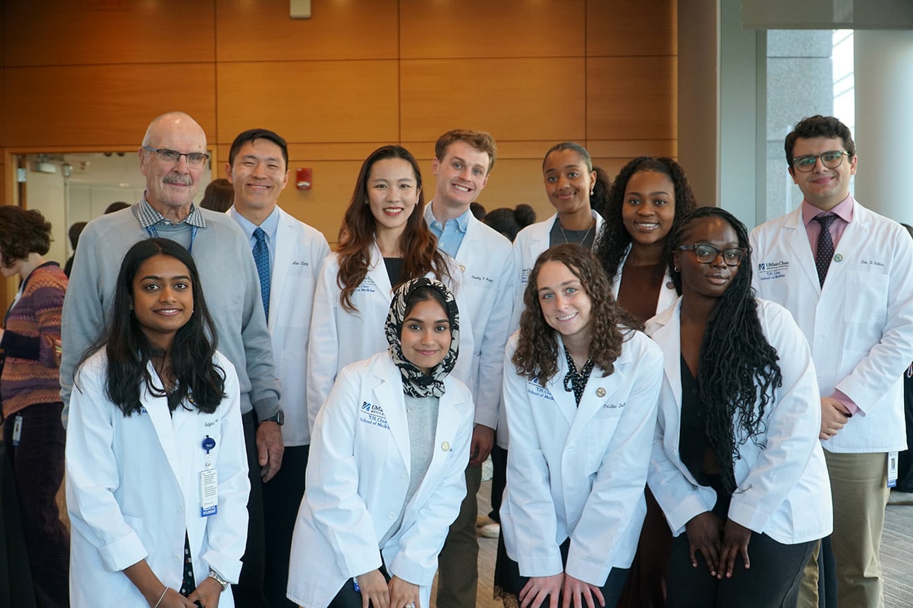 The 10 first-year MD/PhD students take a photo with John Sullivan, MD, professor emeritus in the program in molecular medicine, at the MSTP Pinning and Advancement Ceremony in September