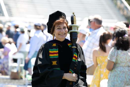 2019 Chancellor’s Medal for Distinguished Service recipient Matilde Castiel, MD, carries the ceremonial commencement mace.