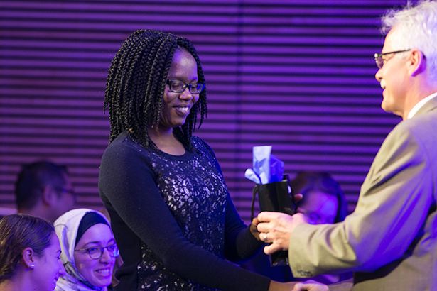 Tatenda Kadungure accepts a gift from Dean Carruthers at the GSBS Recognition Ceremony.