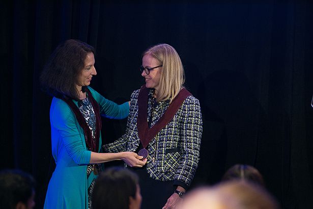 Tiffany Moore Simas, MD, MPH, presents Heather Forkey with the medal for the Joy McCann Professor for Women in Medicine.