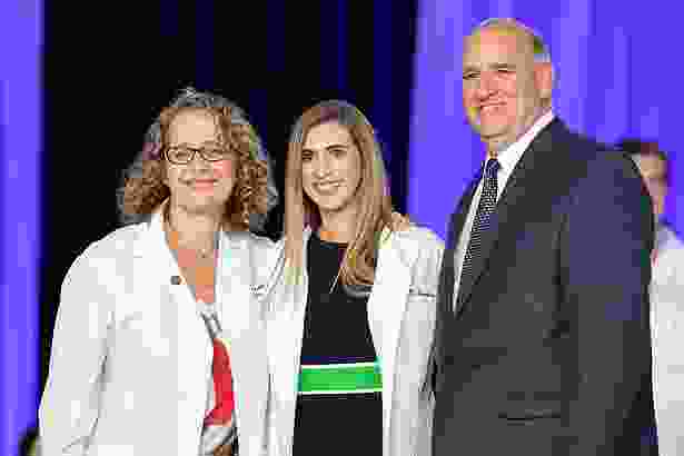 Jenna Lansbury is cloaked in her white coat by her mentor, Lisa Gussak, MD, and her father, William Lansbury