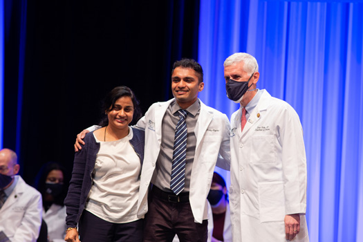 Second-year medical student Akshay Alaghatta, here with David Hatem, MD, receives his white coat.
