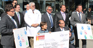 Jack L. Leonard, PhD, (at center, in white coat), is presented with a $250,000 grant from the Hyundai Hope on Wheels program. 