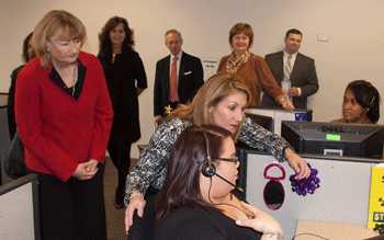 Dawn Dias explains to Lt. Gov. Karyn E. Polito how trained specialists will handle MassOptions calls as Executive Office of Health and Human Services Undersecretary Alice Moore looks on.