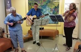 Sharing their talents, Lamar Soutter Library’s band LEGG Up (from left) Sally Gore, Len Levin and Michelle Eberle are pictured here performing in the University Campus lobby on Aug. 25.