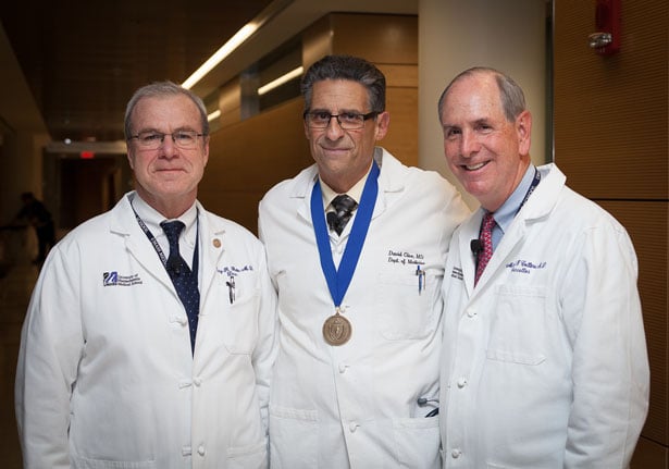 From left, School of Medicine Dean Terence Flotte, MD; keynote speaker David Clive, MD; and Chancellor Michael F. Collins are ready to take the podium at the Second Year Oath Ceremony.