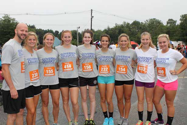 Hudson High School Girls track & field coach Spencer Fortwengler and his team pose for a photo before running the Governor Cellucci Tribute Road Race.