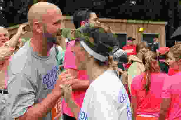 Kate Cellucci crosses the finish line and is congratulated by Spencer Fortwengler, coach of the Hudson High School girls track & field team.
