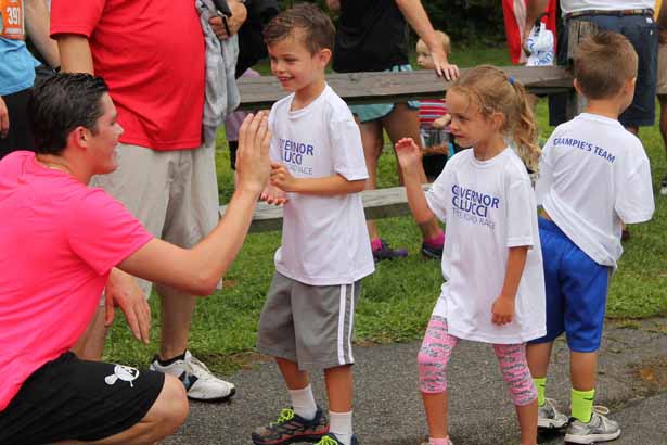 Gov. Cellucci's grandchildren, Rhys and Francesca Adams, and Gabriel Westberg, celebrate with runners at the finish line.