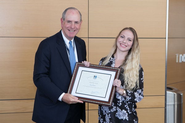 GSBS student Emma Watson receives the Chancellor’s Award from Chancellor Michael F. Collins.