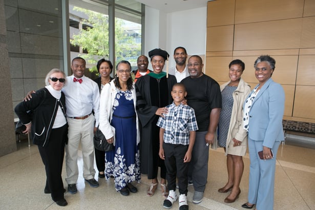 SOM graduate and class speaker Jessica Long is flanked by mother, Adrienne Berry-Burton, and father, Roy Long, along with extended family and friends