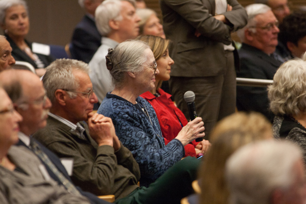 Nancy Erb takes the microphone to ask a question about the research while husband Elisha listens at her left.