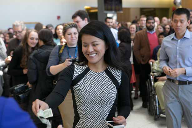 Xingyue Wang antes up her dollar in exchange for her Match envelope. Wang will begin her residency in family medicine at the Swedish Medical Center in Seattle in June.
