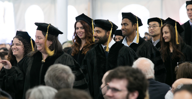 Graduates from the Morningside Graduate School of Biomedical Sciences enter the tent