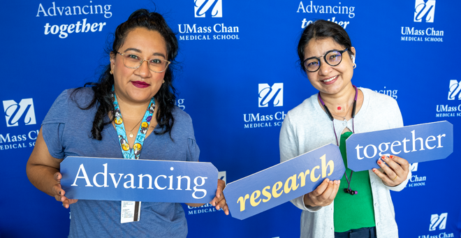 Monserrat Olea Flores and Sandhya Yadav holding up signs that say Advancing research together.