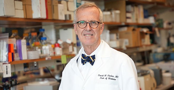 David Harlan, MD, pictured in his lab, wearing a white lab coat, taken May 2022
