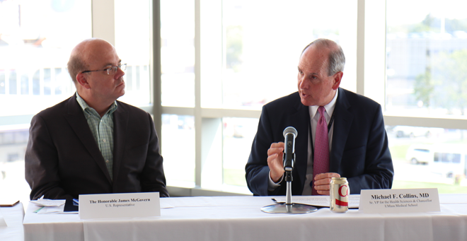U.S. Rep. Jim McGovern, left, listens as Chancellor Michael F. Collins speaks at the forum on NIH funding at UMMS.