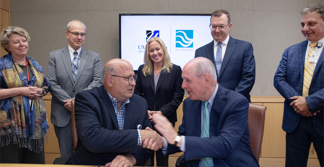 Ray Kruger, MD, shakes hands with Chancellor Michael F. Collins, while Anne Larkin, MD, and Terence R. Flotte, MD, of UMass Chan Medical School and Renee Clark, Jay Lawrence, MD, and Dani Hackner, MD, of Southcoast Health look on. 