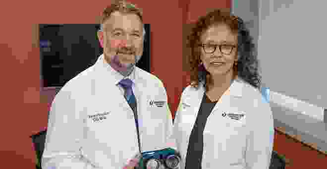 Dr. Houston and Dr. Barrett in lab coats with prism goggles