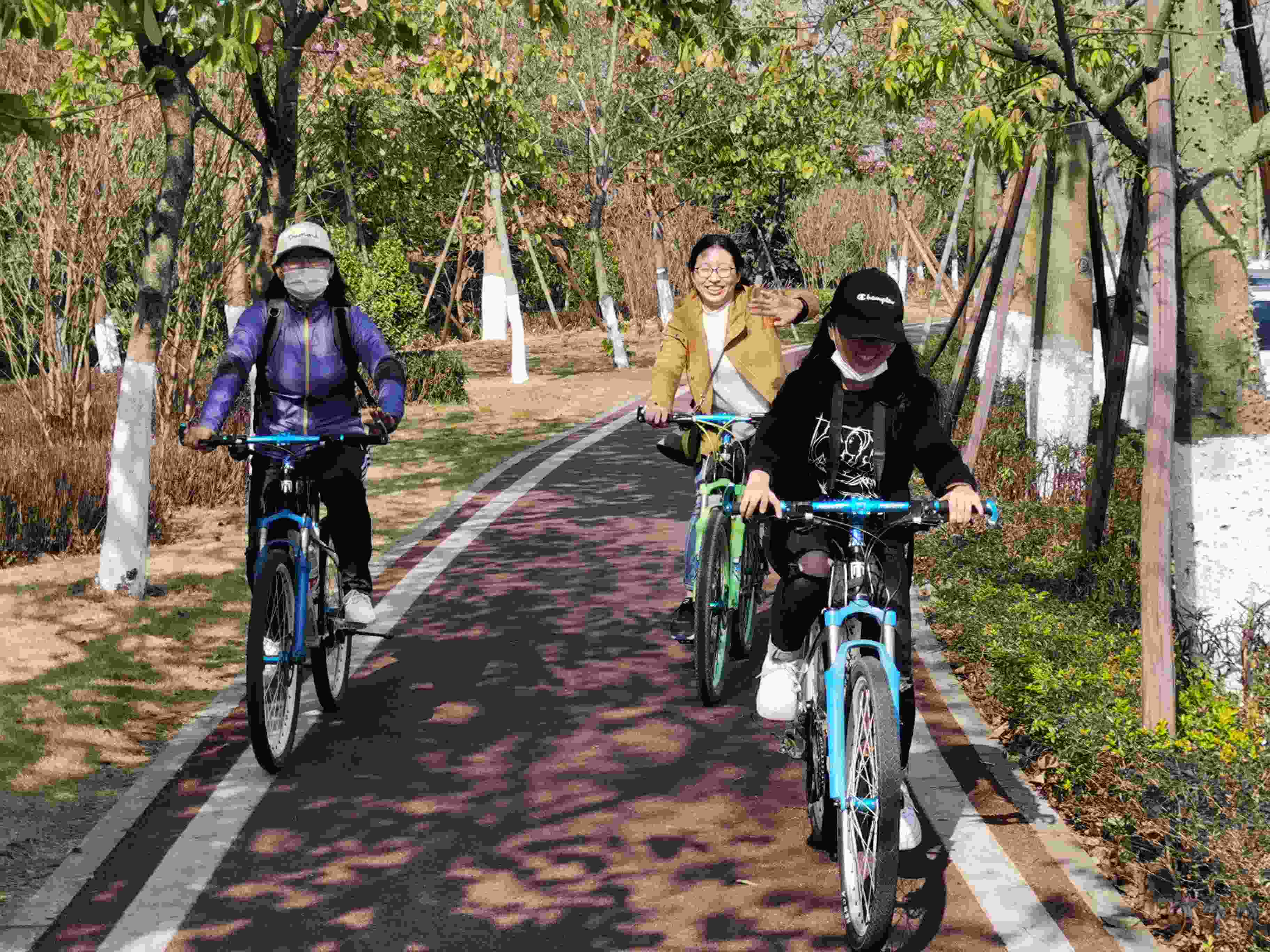A group of three people are riding bikes and smiling.