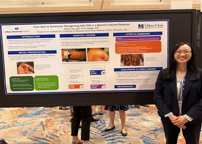 Image of a Primary Care Resident posing in front of a poster