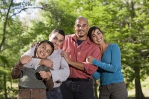Mixed race family members hugging and smiling