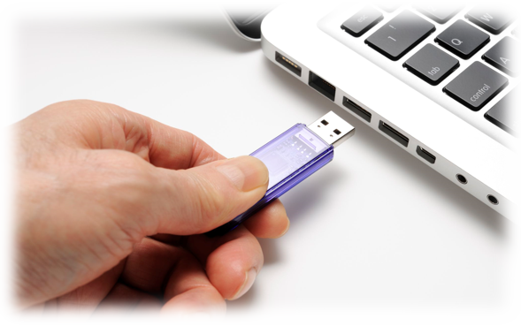 Hand plugging thumb drive into laptop