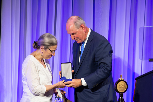 Dr Fingeroth accepts the medallion for her late husband, Robert Finberg, MD, from Chancellor Collins.